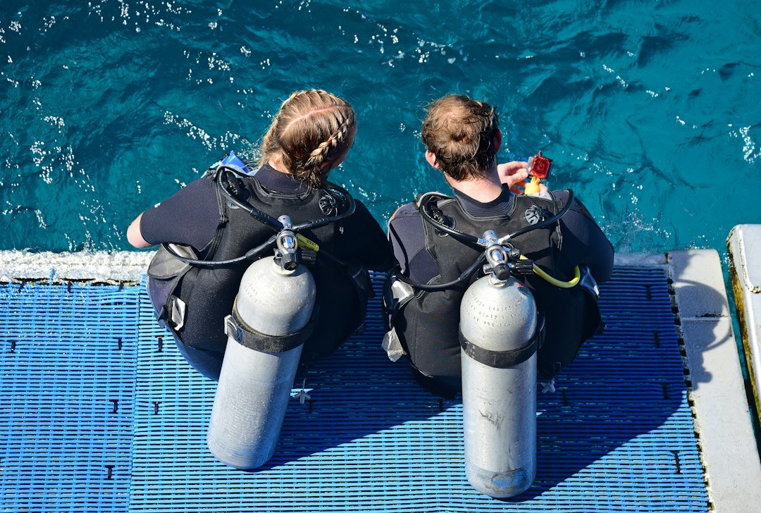 Dos buceadores realizan verificaciones de seguridad antes de entrar al agua